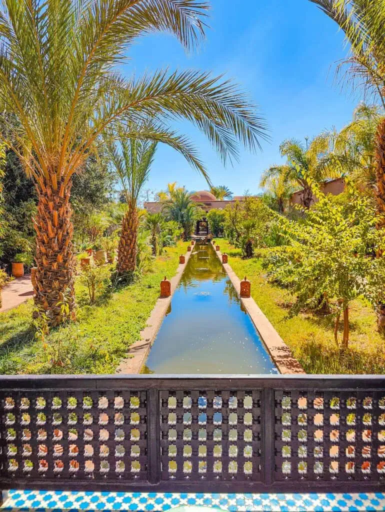 View of a central fountain surrounded by lanterns and palm trees on a sunny day in Marrakech at the Musee de Palmeraie.