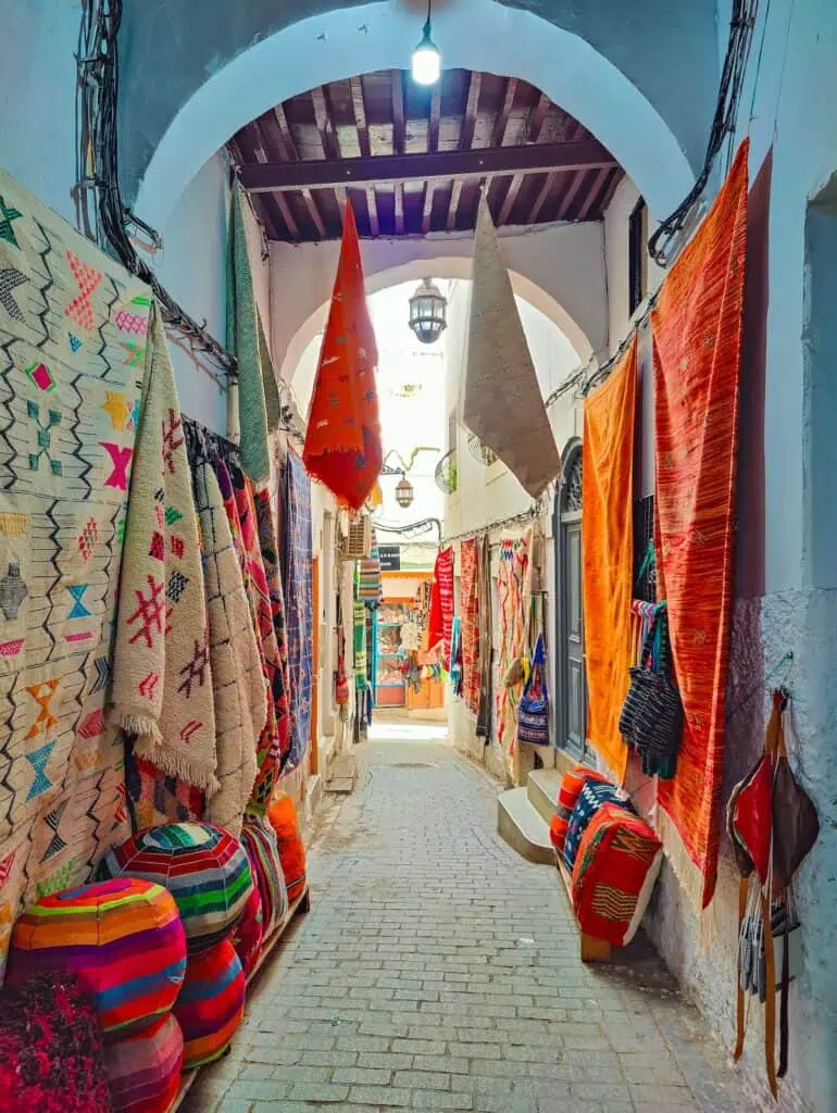 Archway filled with colorful rugs hanging in the doorway and on the walls.