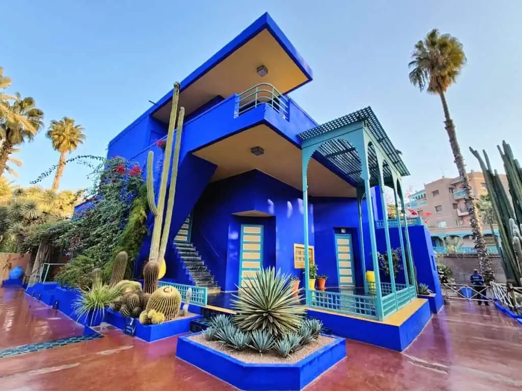 A diagonal view of the blue, art-deco building inside Jardin Majorelle in Marrakech.