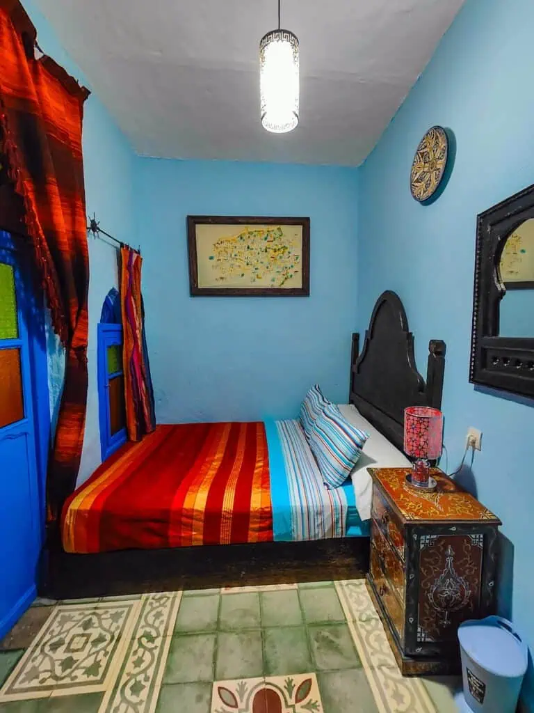 A small bedroom with blue walls and a bed with a nightstad at Dar Antonio.