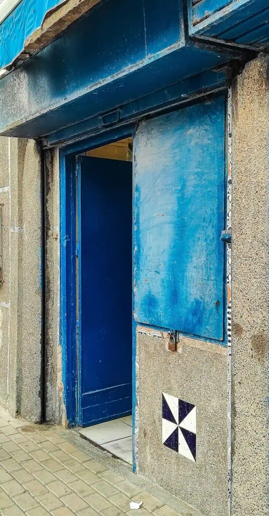 Nondescript blue door that serves as the entrance to the liquor store in Essaouira.