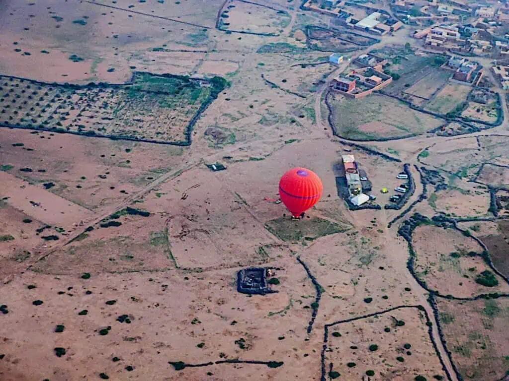 Red hot air balloon sitting on the ground getting ready to take off in Marrakech.