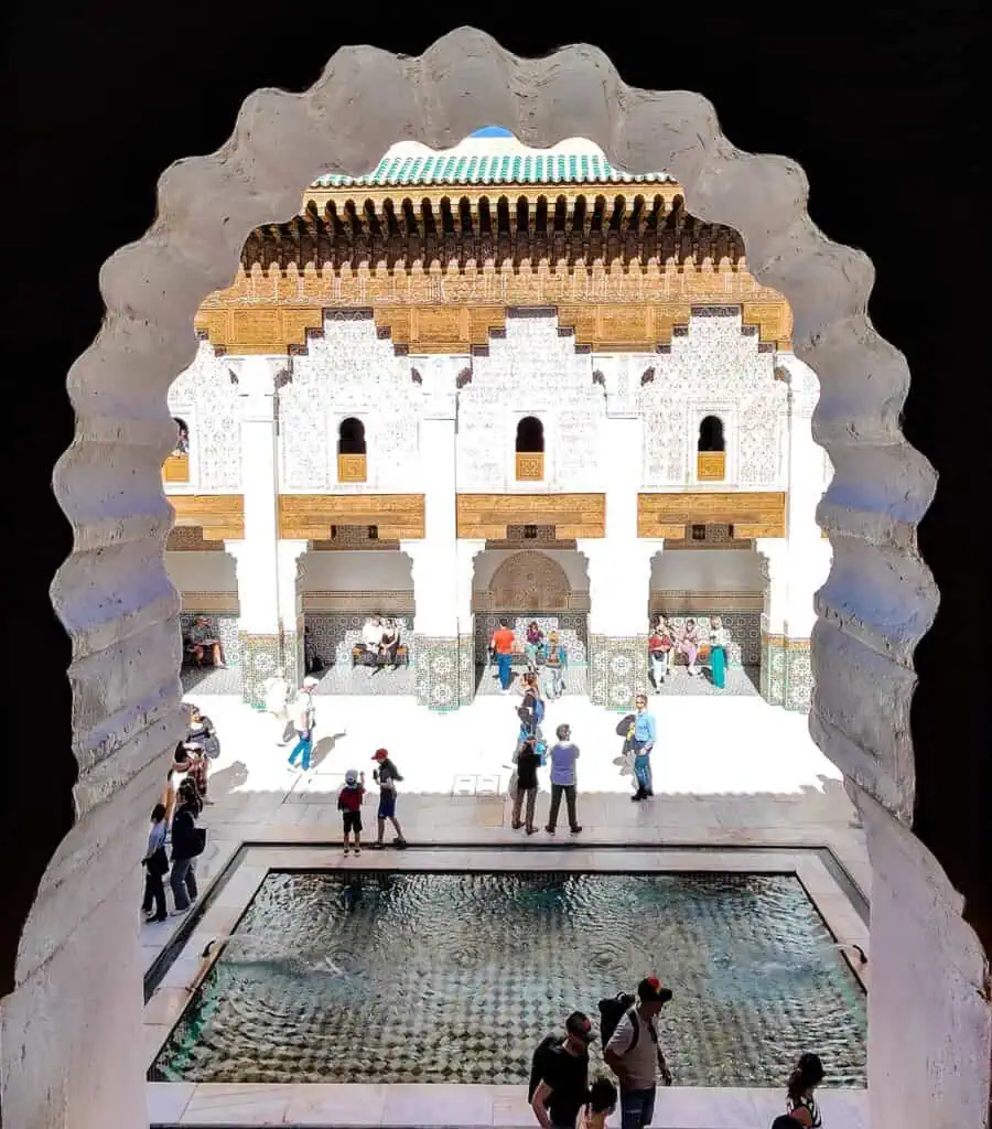 View through a middle eastern style window of the courtyard and fountain of Ben Youssef Madrasa in Marrakech.