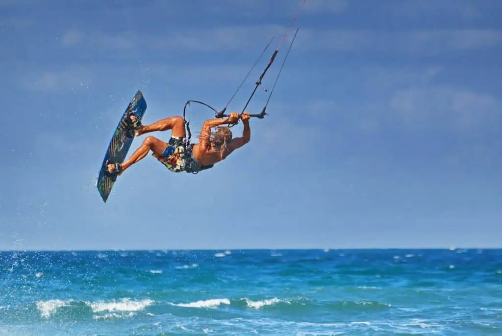 kiteboarder athlete performing kiteboarding kitesurfing tricks unhooked. Learn how to do this when kitesurfing in Essaouira.