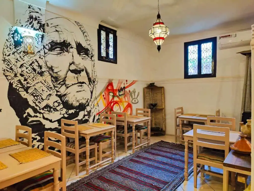 View of the white interior of Kui Zen with a Moroccan rug on the floor and white walls.