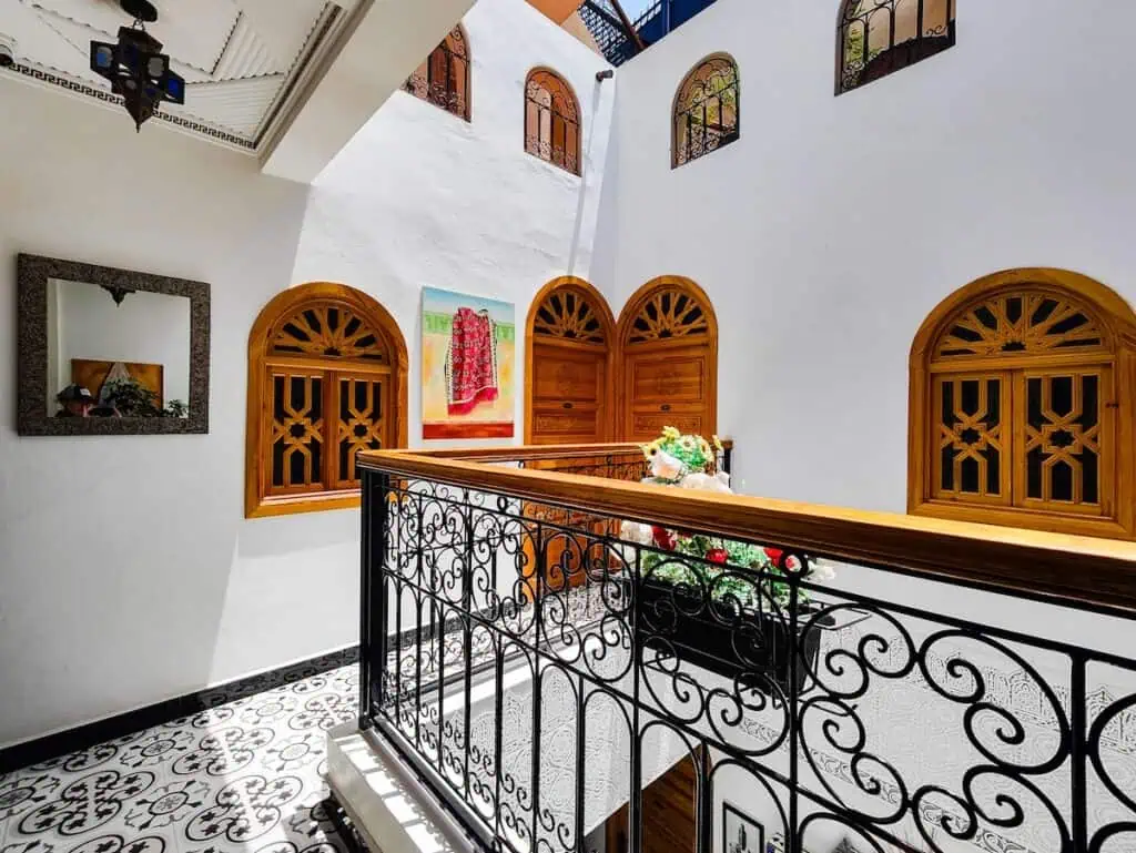 View of the white hallways and wooden windows and doors of Dar Yassine Riad.