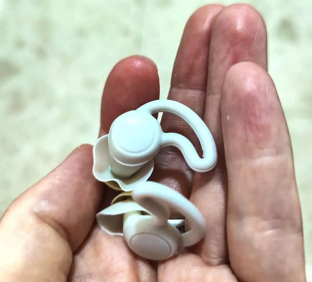 View of two white, reusable ear plugs in my hand that I use in Morocco as part of my Morocco packing list. 