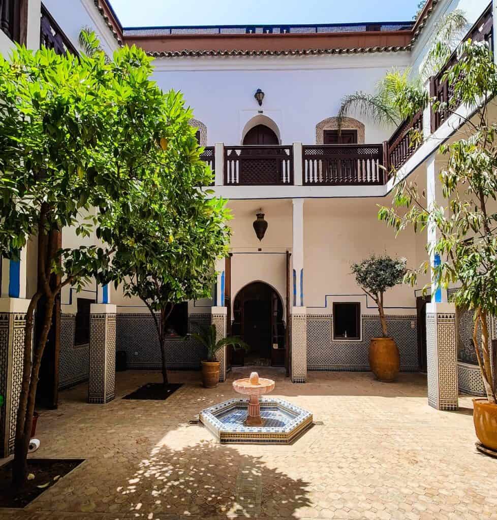 View of the white exterior, two floors, and inner courtyard of Equity Point in Marrakech.