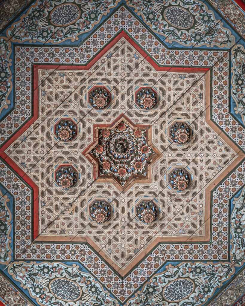 View of a geometris tile mosaic in November in marrakech. You can see beautiful blue and read flower shapes on the floor.