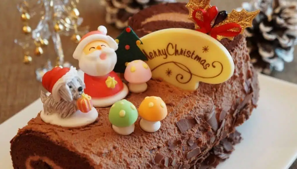 View of a chocolate Christmas cake that looks like a log with Christmas figures and mushrooms on top. You can find this Buche de Noel at many bakeries during Christmas in Marrakech.