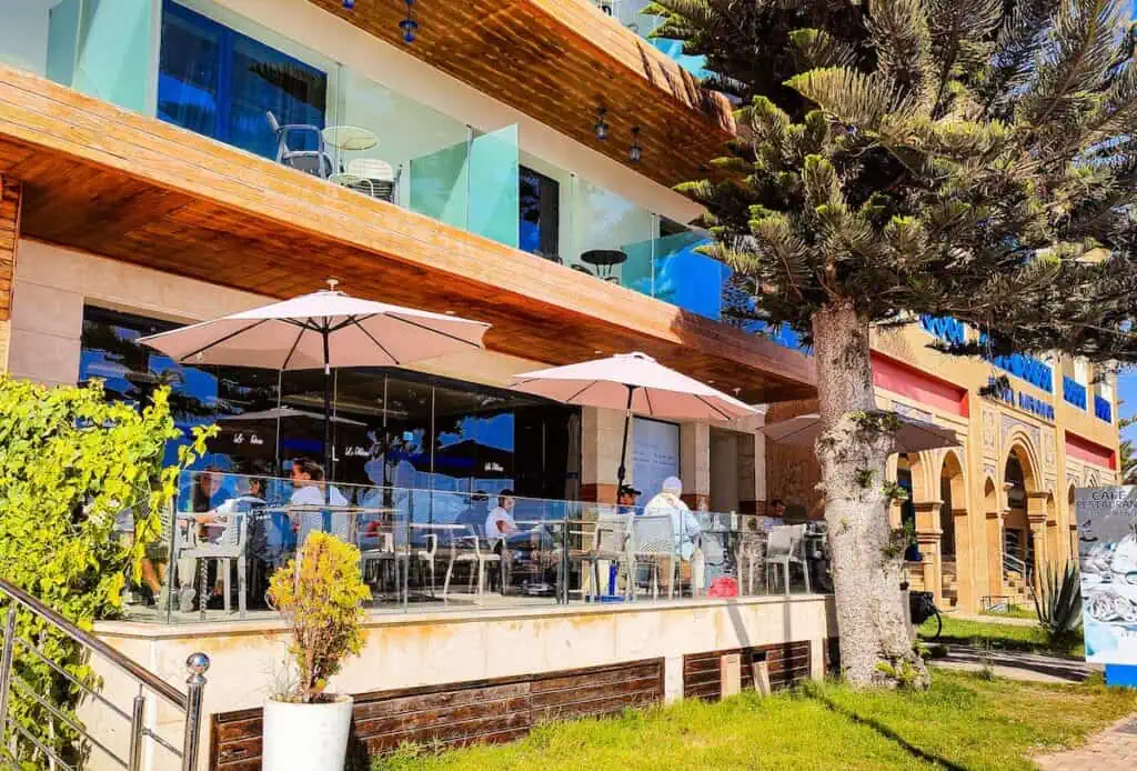 The outdoor terrace at La Marre with umbrellas to cover tables at one of the best places for coworking in Essaouira.