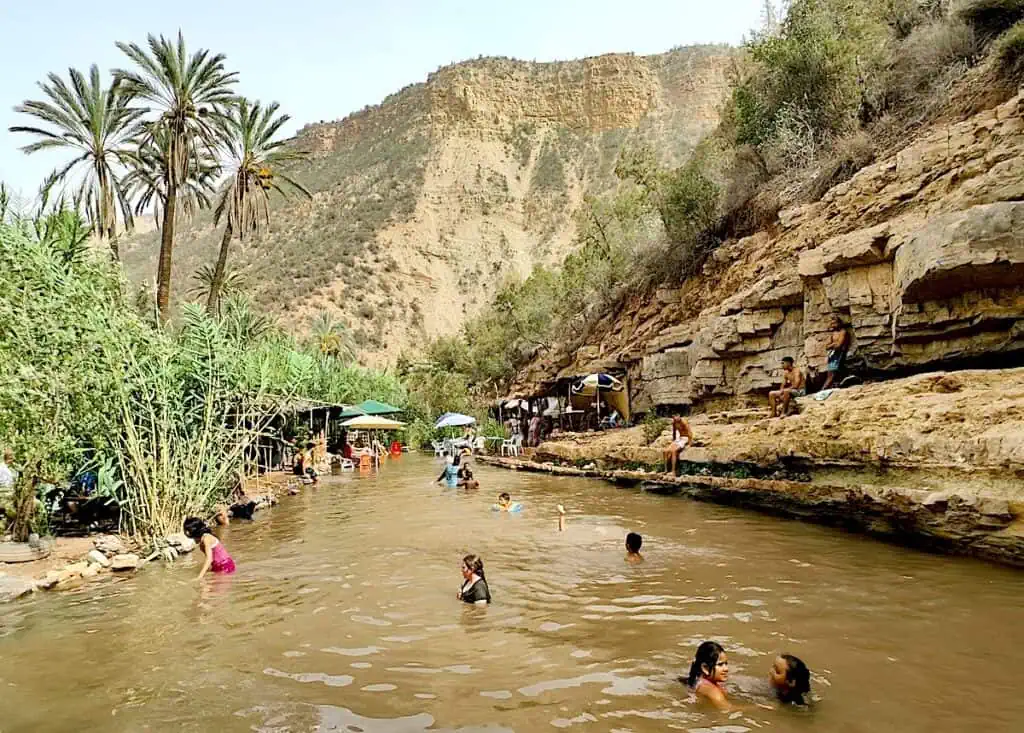 A view of the brown water and people swimming in Paradise Valley just outside of Agadir. If you want to know hot to get to Essaouira then you can also leave from Agadir.
