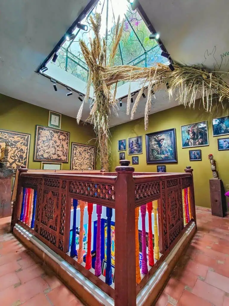 Diagonal view of Galerie Conil with colorful banisters and an open air ceiling.