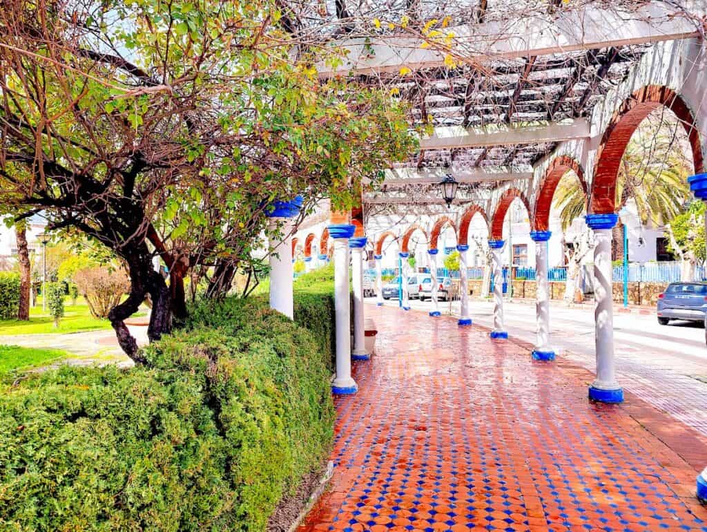 The well-manicured bushes, red tiled walkways, and white arches that make up Plaze Mohammed V in Chefchaouen.