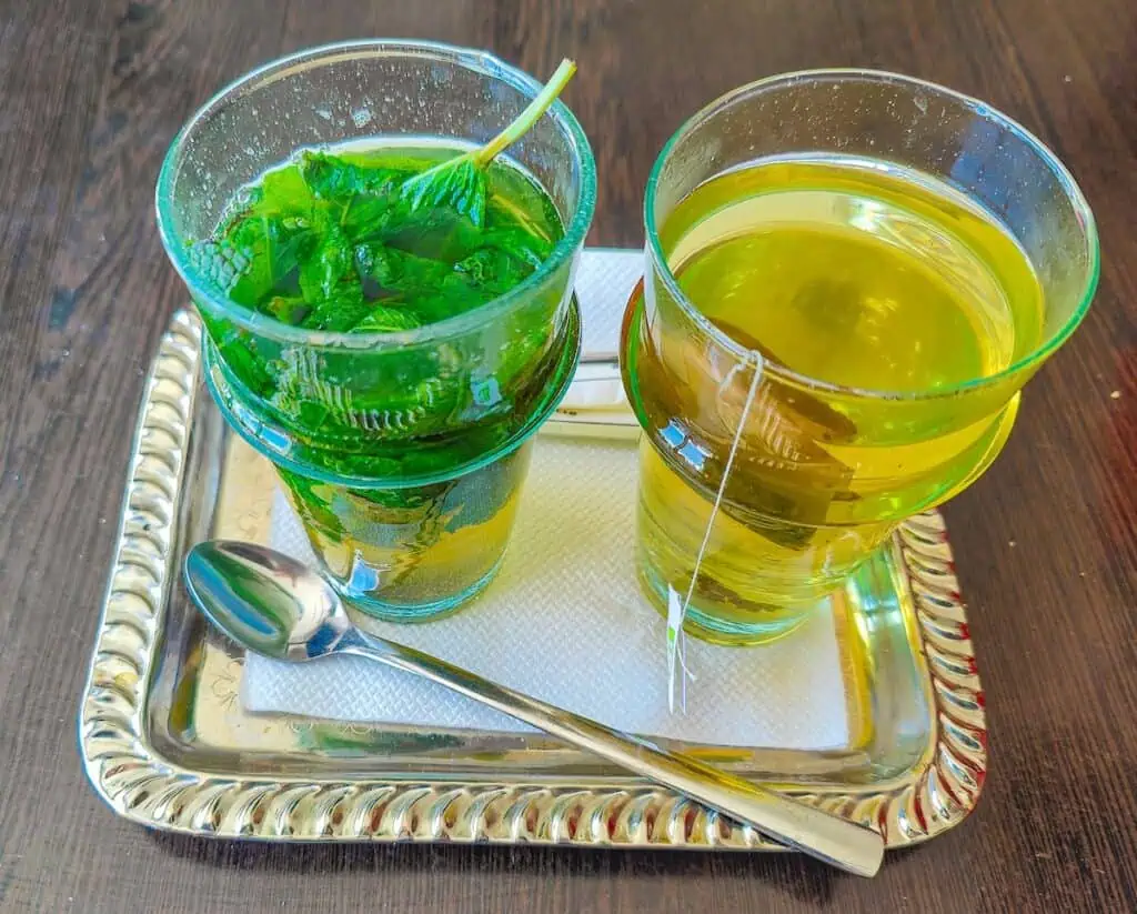 View of two glasses of tea served on a silver tray with a spoon at one of the best cafes in Tangier.